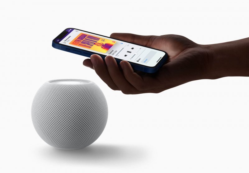 The Apple HomePod mini next to an iPhone.